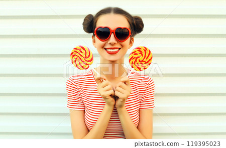 Summer portrait of happy smiling young woman with lollipop on white background Summer portrait of happy smiling young woman with lollipop on white background 119395023