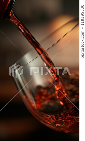 Pouring red wine from bottle. 119395330