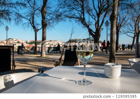 Drinks on the table in a restaurant, a glass of white wine and an ashtray on a white table of a cafe in the park 119395395