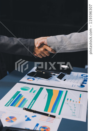 Handshake as successful negotiation ending, close-up. Unknown business people shaking hands after contract signing in modern office Handshake as successful negotiation ending, close-up. Unknown business people shaking hands after contract signing in modern office 119396307