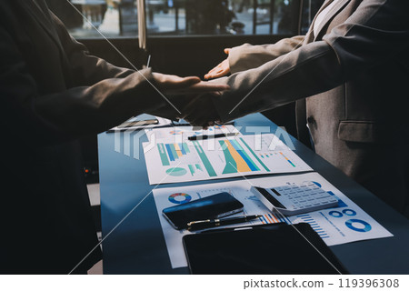 Handshake as successful negotiation ending, close-up. Unknown business people shaking hands after contract signing in modern office Handshake as successful negotiation ending, close-up. Unknown business people shaking hands after contract signing in modern office 119396308