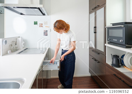 Woman opening cupboard, housewife, housework, cooking, cleaning up Woman opening cupboard, housewife, housework, cooking, cleaning up 119396552