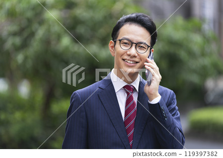 A businessman in his late 30s talking on a smartphone 119397382