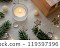Candle Christmas gift on table. Postcard for New Year greetings 119397396
