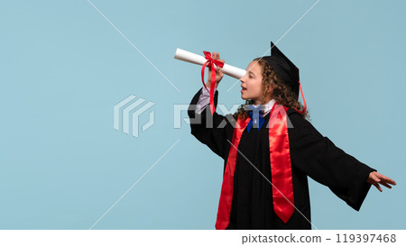 Young girl in graduation gown holding diploma like telescope. 119397468