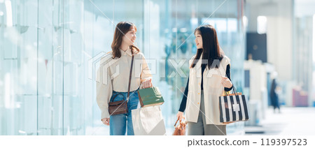 Young women with friends enjoying shopping 119397523