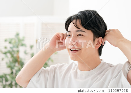 A man doing his hair, smiling A man doing his hair, smiling 119397958