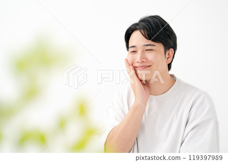 一個男人摸著臉頰微笑 119397989