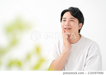 一個男人摸著臉頰微笑 119397990