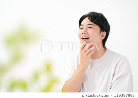 一個男人摸著臉頰微笑 119397992