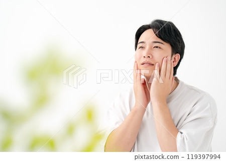 一個男人摸著臉頰微笑 119397994