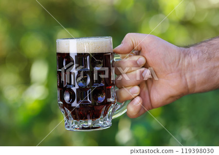 closeup male hand with mug of dark beer closeup male hand with mug of dark beer 119398030