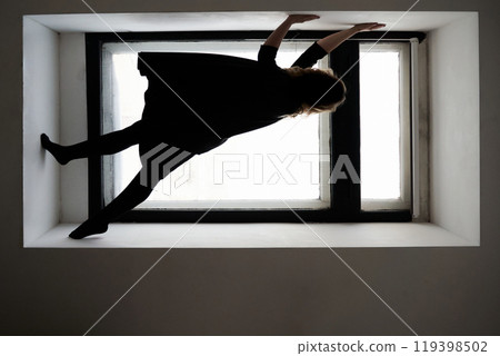 Creative indoor photography silhouette of a woman balancing gracefully 119398502