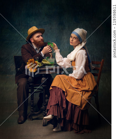 Cinematic portrait of man and woman sitting and drinking alcohol drinks over dark vintage, medieval background 119398611
