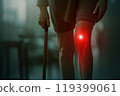 Elderly Woman Suffering from Knee Pain Using a Cane 119399061