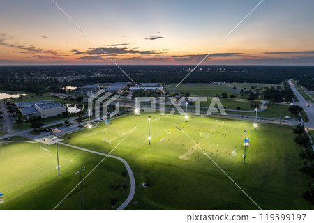 Sportsmen training in soccer game on illuminated football stadium in public sports park in North Port, Florida Sportsmen training in soccer game on illuminated football stadium in public sports park in North Port, Florida 119399197