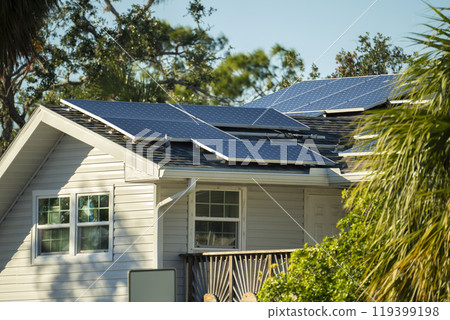 Standard american residential house with rooftop covered with solar photovoltaic panels for producing of clean electrical energy in suburban rural area. Concept of investment in autonomous home 119399198