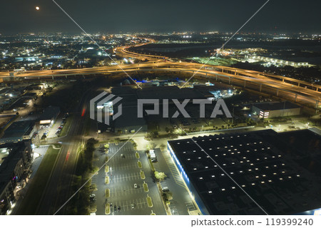 View from above of many parked cars on illuminaded parking lot at night in front of a superstore. Place for vehicles in front of a shopping mall center View from above of many parked cars on illuminaded parking lot at night in front of a superstore. Place for vehicles in front of a shopping mall center 119399240