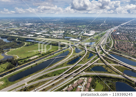 View from above of USA transportation infrastructure. American freeway intersection with fast driving cars and trucks in Miami, Florida View from above of USA transportation infrastructure. American freeway intersection with fast driving cars and trucks in Miami, Florida 119399245