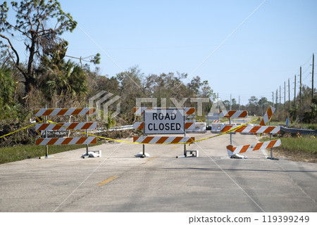 Warning roadworks sign and safety barrier on city street during maintenance repair work 119399249