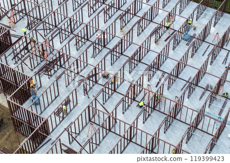 Industrial construction site with workers assembling metal frame building. Development of residential housing in America. Real estate market in the USA Industrial construction site with workers assembling metal frame building. Development of residential housing in America. Real estate market in the USA 119399423