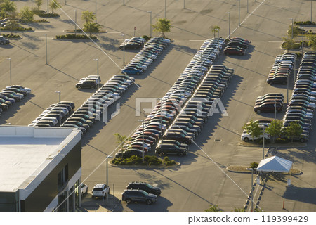 Large parking lot of local dealer with many brand new cars parked for sale. Development of american automotive industry and distribution of manufactured vehicles concept 119399429