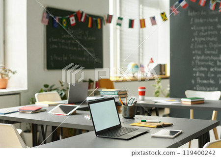 Background image of school classroom decorated for international conference with open laptop on desk, copy space 119400242