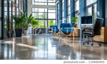 A bright office environment with chic furniture and greenery. Large windows bring in natural light 119400493