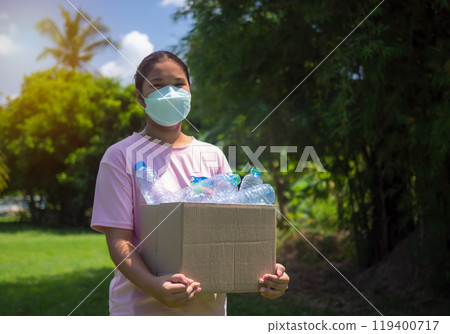 Recycle concept, woman collecting garbage and holding a recycle bin with plastic bottles in the outdoors, Plastic-free, Junk food plastic packaging, Reduction environmental pollution. 119400717