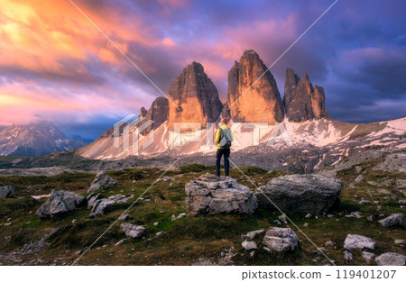 Girl with backpack and mountain peaks at colorful sunset in fall Girl with backpack and mountain peaks at colorful sunset in fall 119401207