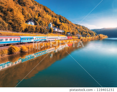 Aerial view of high speed train moving near lake in mountains 119401231