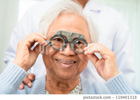 Optometrist checking Asian elderly woman ophthalmic vision eye test and using optical trial frame. Optometrist checking Asian elderly woman ophthalmic vision eye test and using optical trial frame. 119401318