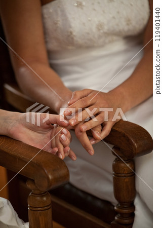 An Intimate Moment Wedding Rings Adorning Hands Together in a Beautiful Ceremony Setting An Intimate Moment Wedding Rings Adorning Hands Together in a Beautiful Ceremony Setting 119401440