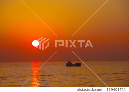 Sunset over the sea and a ship 119401711