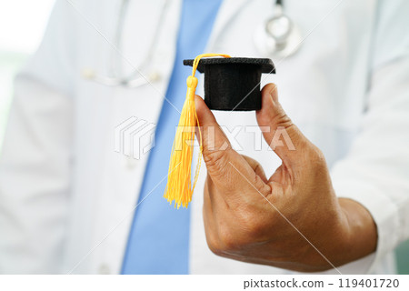 Asian woman doctor holding graduation hat in hospital, Medical education concept. Asian woman doctor holding graduation hat in hospital, Medical education concept. 119401720