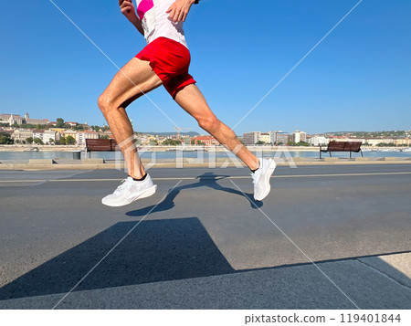 male athlete runner, shadow on asphalt of running man male athlete runner, shadow on asphalt of running man 119401844