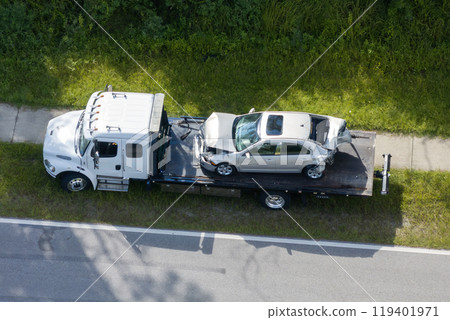 Car crash site with tow truck loading destroyed vehicle on American street. Emergency services personnel responding to accident in Florida, USA Car crash site with tow truck loading destroyed vehicle on American street. Emergency services personnel responding to accident in Florida, USA 119401971