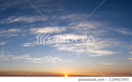 Colorful sunset sky with setting sun behind vivid orange and yellow clouds Colorful sunset sky with setting sun behind vivid orange and yellow clouds 119401993