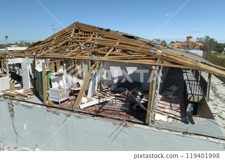Consequences of natural disaster. Damaged house roof with missing shingles and broken apart walls after hurricane Ian in Florida 119401998