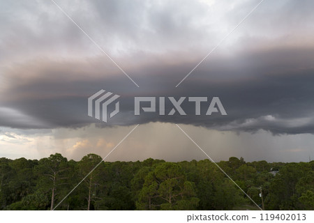 Dark stormy clouds forming on gloomy sky before heavy rainfall over suburban town area 119402013