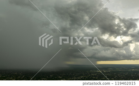 Dark stormy clouds forming on gloomy sky during heavy rainfall season over suburban town area Dark stormy clouds forming on gloomy sky during heavy rainfall season over suburban town area 119402015