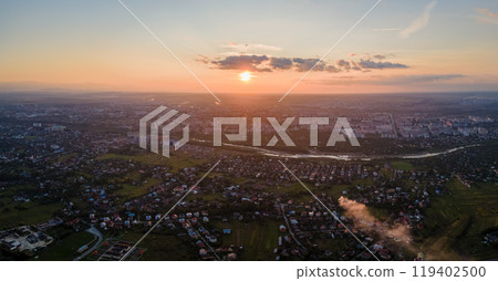 Aerial view from airplane window at high altitude of earth covered with white thin layer of misty haze and distant clouds at sunset Aerial view from airplane window at high altitude of earth covered with white thin layer of misty haze and distant clouds at sunset 119402500