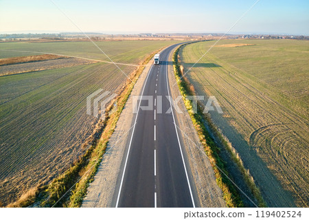 Aerial view of cargo truck driving on highway hauling goods. Delivery transportation and logistics concept Aerial view of cargo truck driving on highway hauling goods. Delivery transportation and logistics concept 119402524