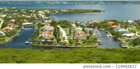 Aerial view of rural private houses in remote suburbs located near Florida wildlife wetlands with green vegetation on sea bay shore. Living close to nature concept 119402617