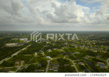 Aerial view of small town America suburban landscape with private homes between green palm trees in Florida quiet residential area Aerial view of small town America suburban landscape with private homes between green palm trees in Florida quiet residential area 119402624