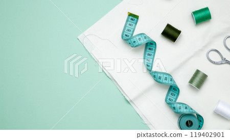 Composition with various threads and sewing accessories on green background. Top view, copy space Composition with various threads and sewing accessories on green background. Top view, copy space 119402901