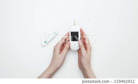 Female hands holding glucometer for measuring blood glucose levels,  lancet. Concept of worldwide diabetes awareness 119402912