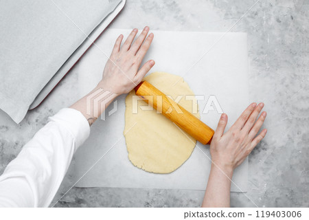Making different shapes of fall cookies for Halloween. Woman rolling out dough Making different shapes of fall cookies for Halloween. Woman rolling out dough 119403006