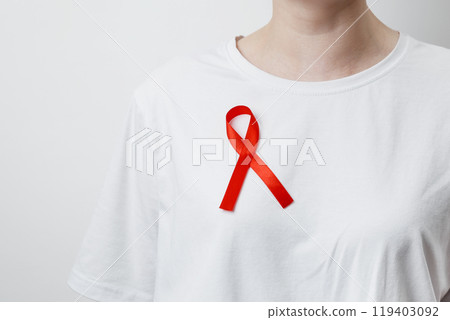 Woman wears red AIDS awareness ribbon. World AIDS Day Woman wears red AIDS awareness ribbon. World AIDS Day 119403092