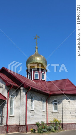 vertical image of orthodox chapel or small church with one golden dome and red roof on sunny day, religious christian architecture small forms, place for prayers in orthodoxy 119403725